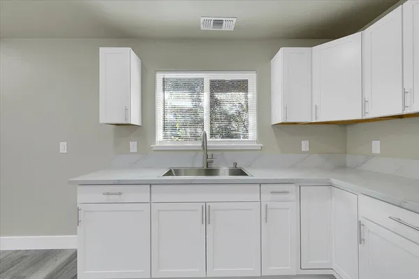 a kitchen with white cabinets and a sink