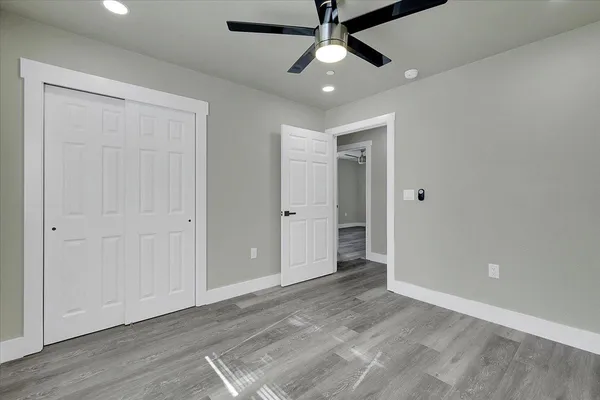 an empty room with fan ceiling fan and windows