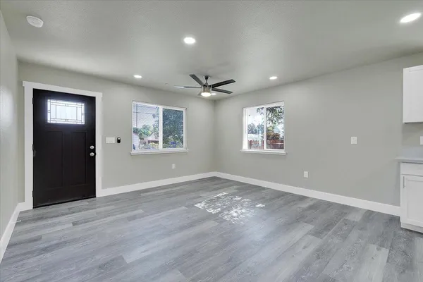 a view of an empty room with a window and a ceiling fan