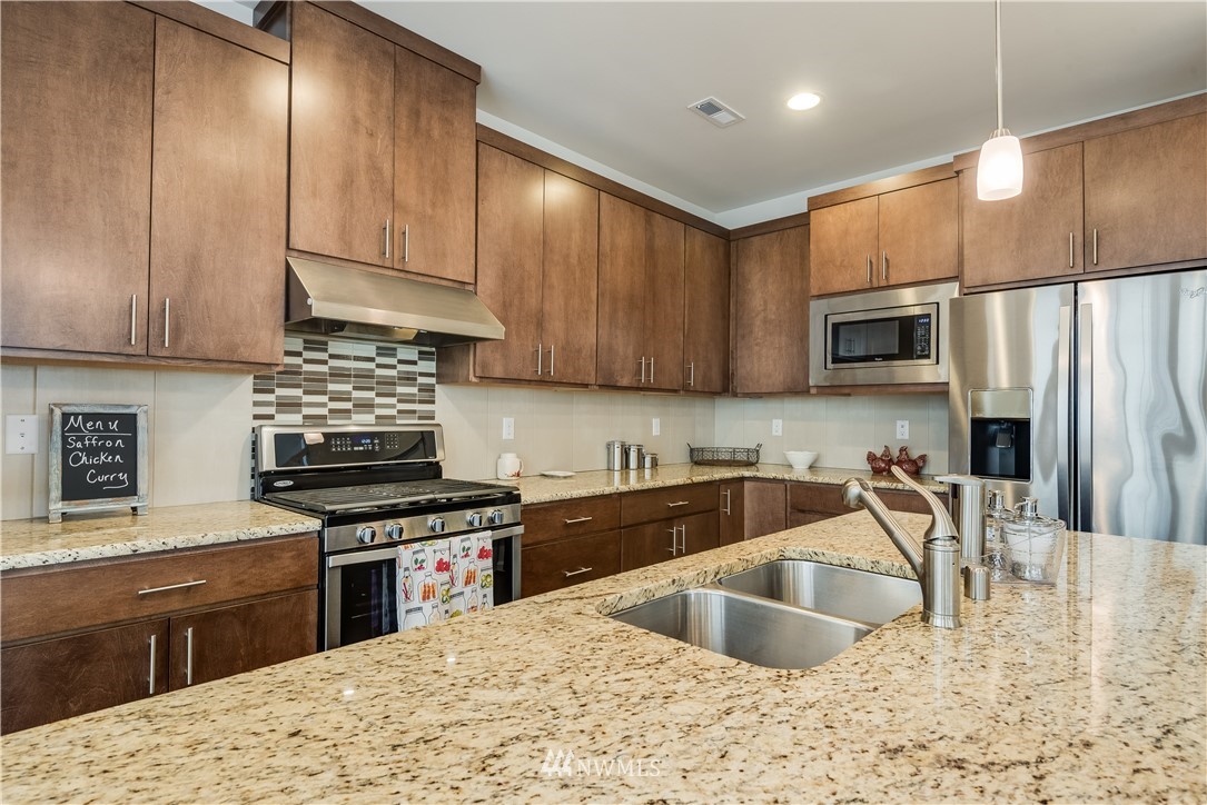 4408 186th Street Southeast Bothell, WA 98012 - Photo 7 of 23 a kitchen with kitchen island granite countertop a sink stainless steel appliances and cabinets