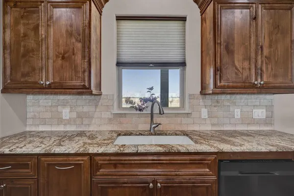 a kitchen with granite countertop a sink and cabinets
