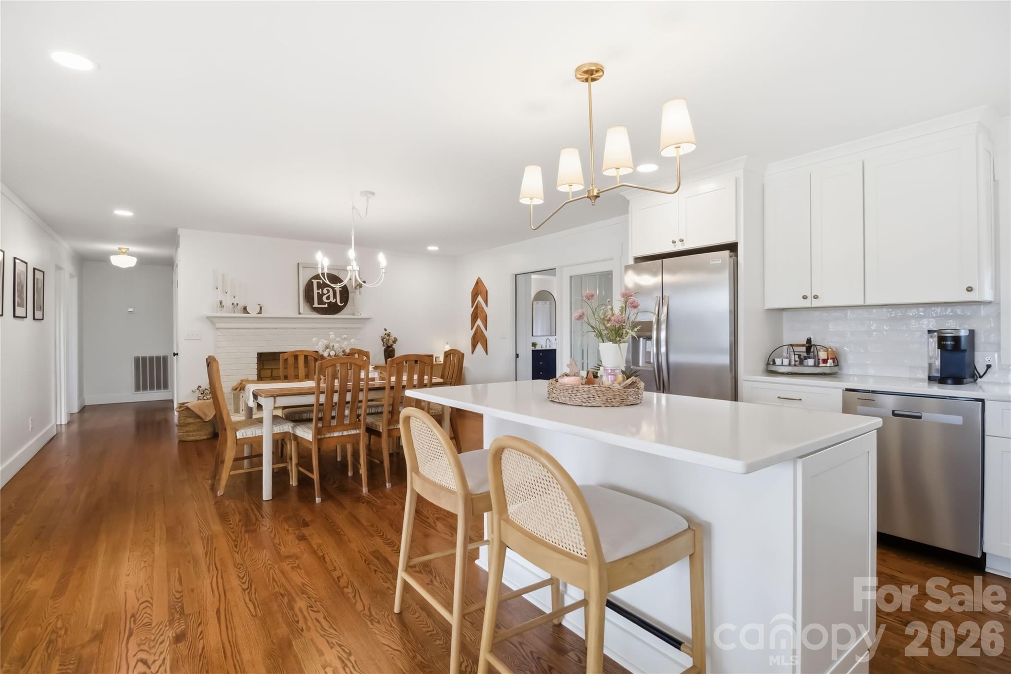 28461 Canton Road Albemarle, NC 28001 - Photo 12 of 30 a kitchen with stainless steel appliances a dining table chairs stove and white cabinets