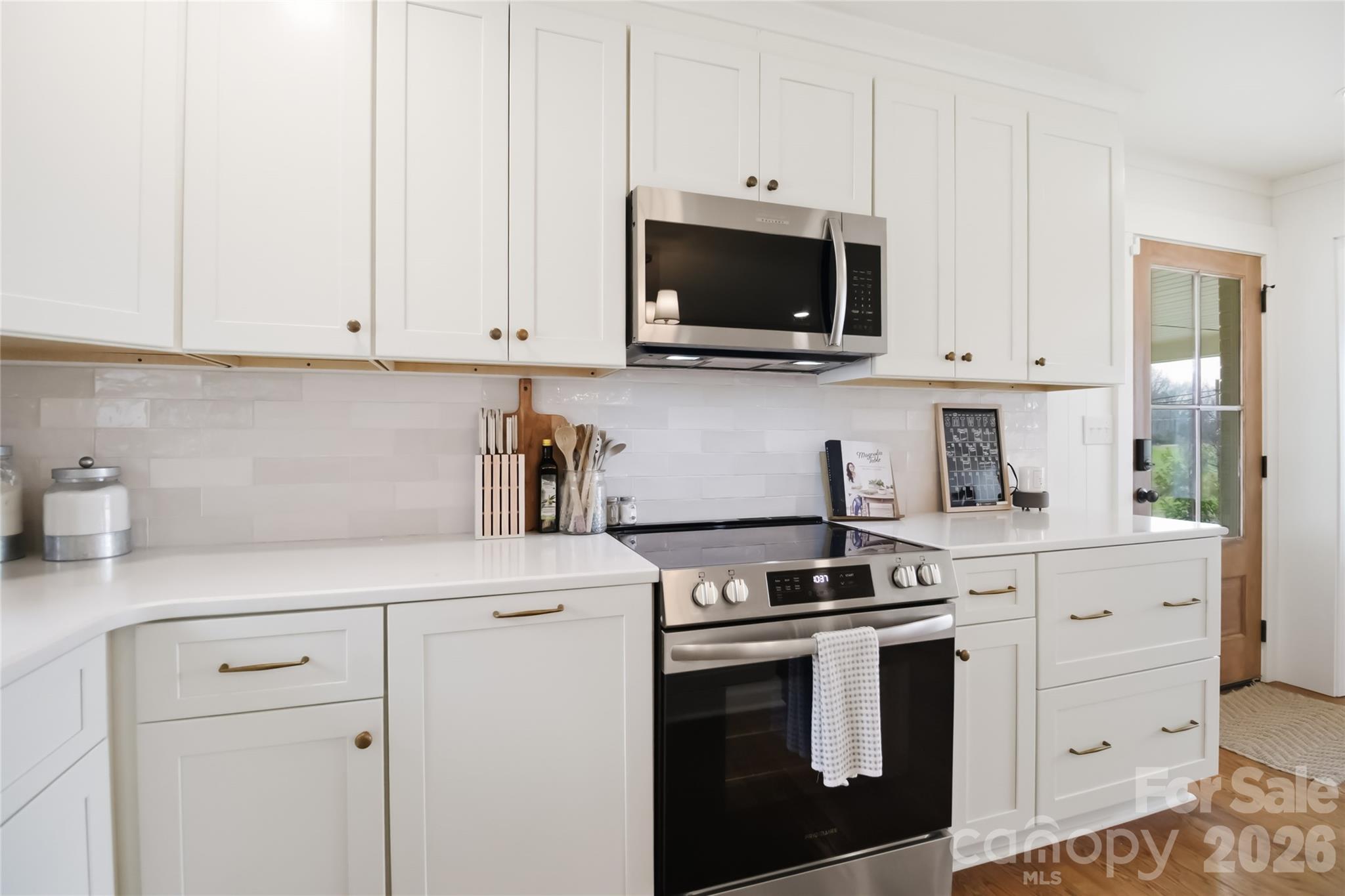28461 Canton Road Albemarle, NC 28001 - Photo 10 of 30 a kitchen with white cabinets and stainless steel appliances