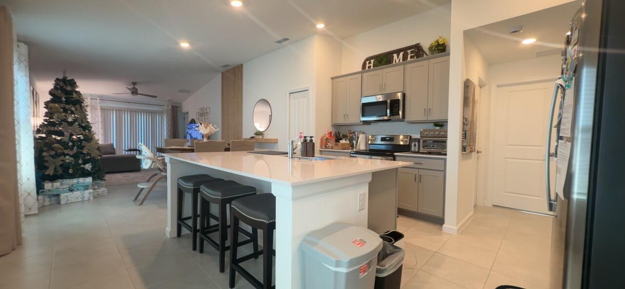 682 Papillon Street Southwest Palm Bay, FL 32908 - Photo 20 of 30 a kitchen with kitchen island a sink stove and refrigerator