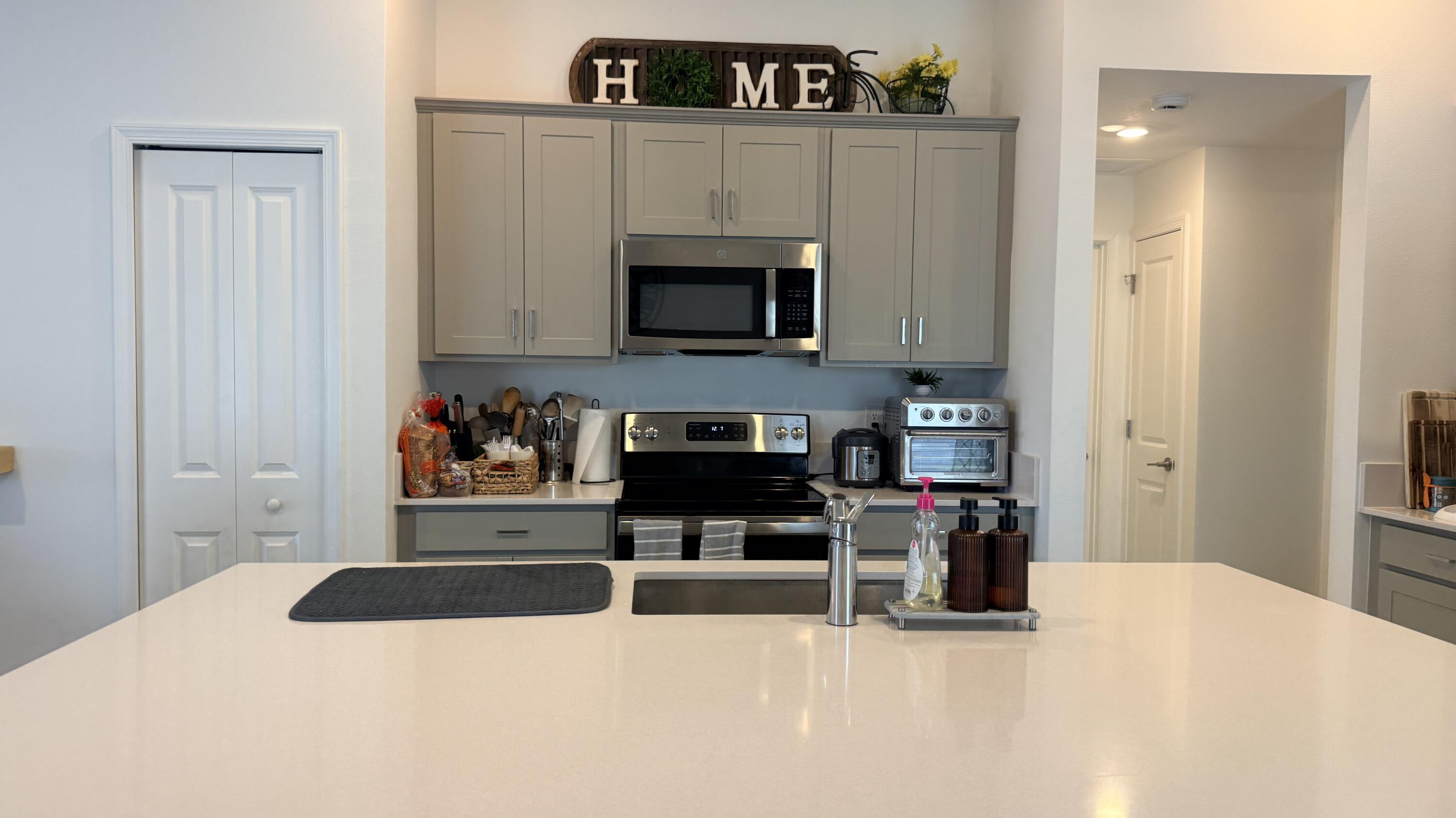 682 Papillon Street Southwest Palm Bay, FL 32908 - Photo 9 of 30 a kitchen with stainless steel appliances a stove and cabinets