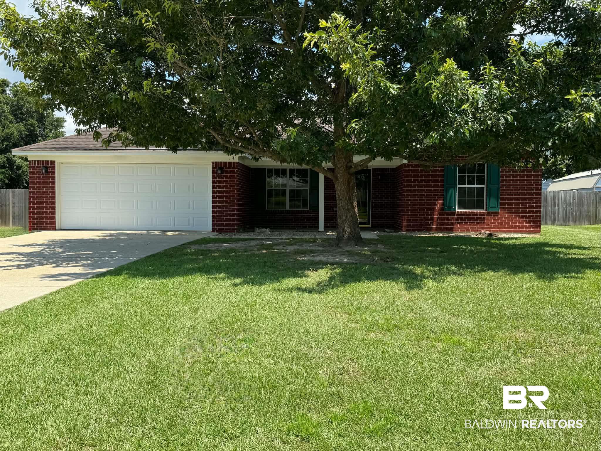 123 Pennbrooke Loop Foley, AL 36535 - Photo 2 of 49 Brick exterior home featuring a two-car garage, mature front yard tree, and an expansive front lawn