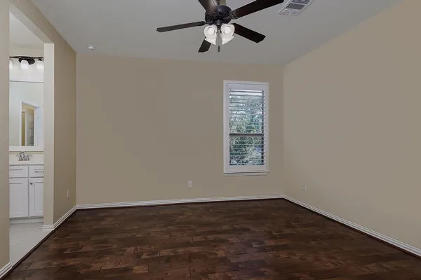 an empty room with a window and a ceiling fan