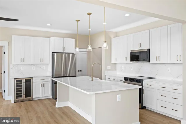 a kitchen with stainless steel appliances granite countertop a sink a oven and a large window with wooden floor