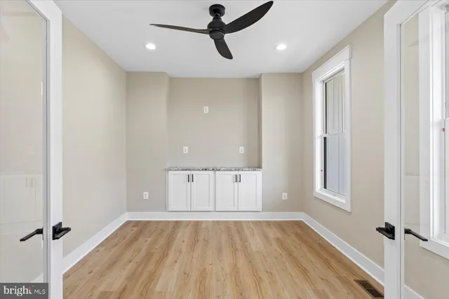 a bathroom with a granite countertop sink vanity mirror and toilet