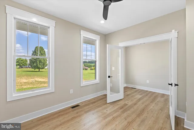 a view of an empty room with wooden floor and stairs