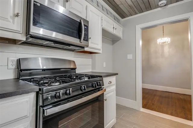 a kitchen with stainless steel appliances granite countertop a stove and a microwave