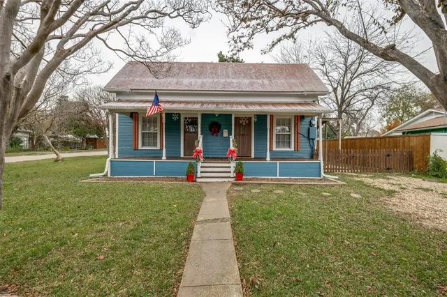 a view of a brick house with a large windows and a large tree