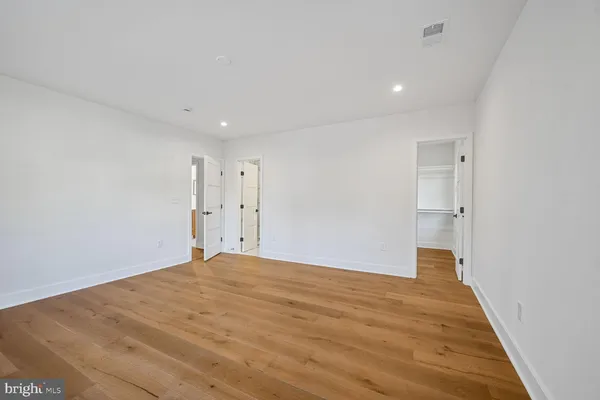 an empty room with wooden floor and window