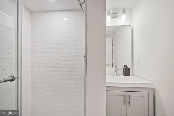a bathroom with a tub sink and mirror