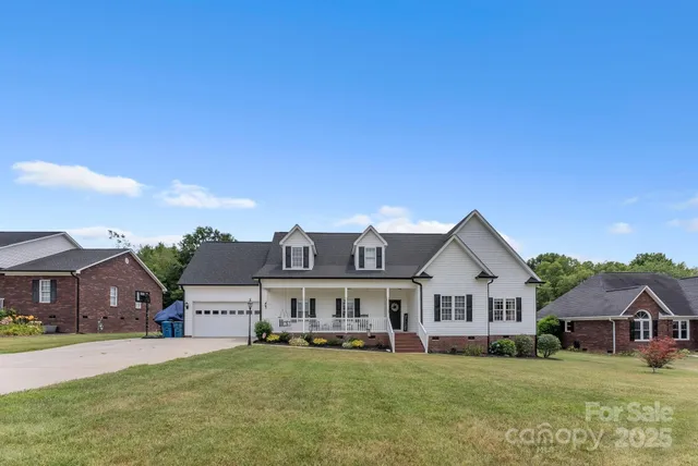 a view of a house with a big yard and large trees