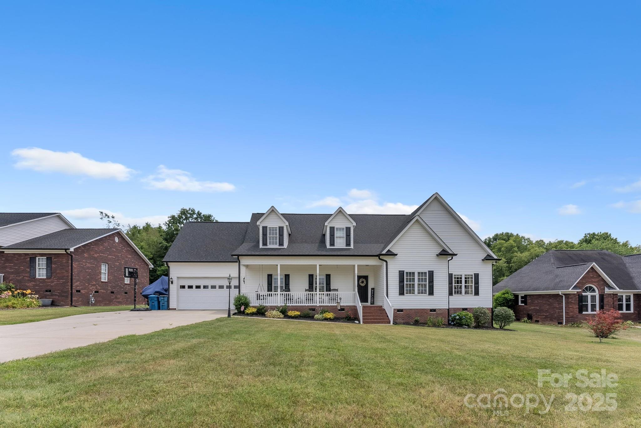 a view of a house with a big yard and large trees
