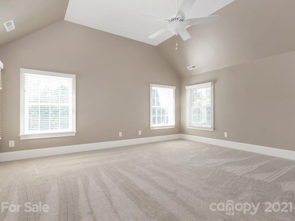 225 Cattle Ridge Road Marvin, NC 28173 - Photo 22 of 42 an empty room with windows and chandelier fan