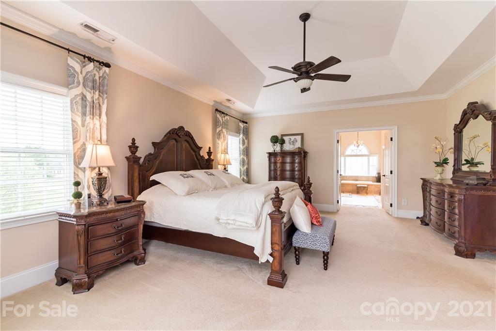 225 Cattle Ridge Road Marvin, NC 28173 - Photo 25 of 42 a bed room with a bed and a chandelier