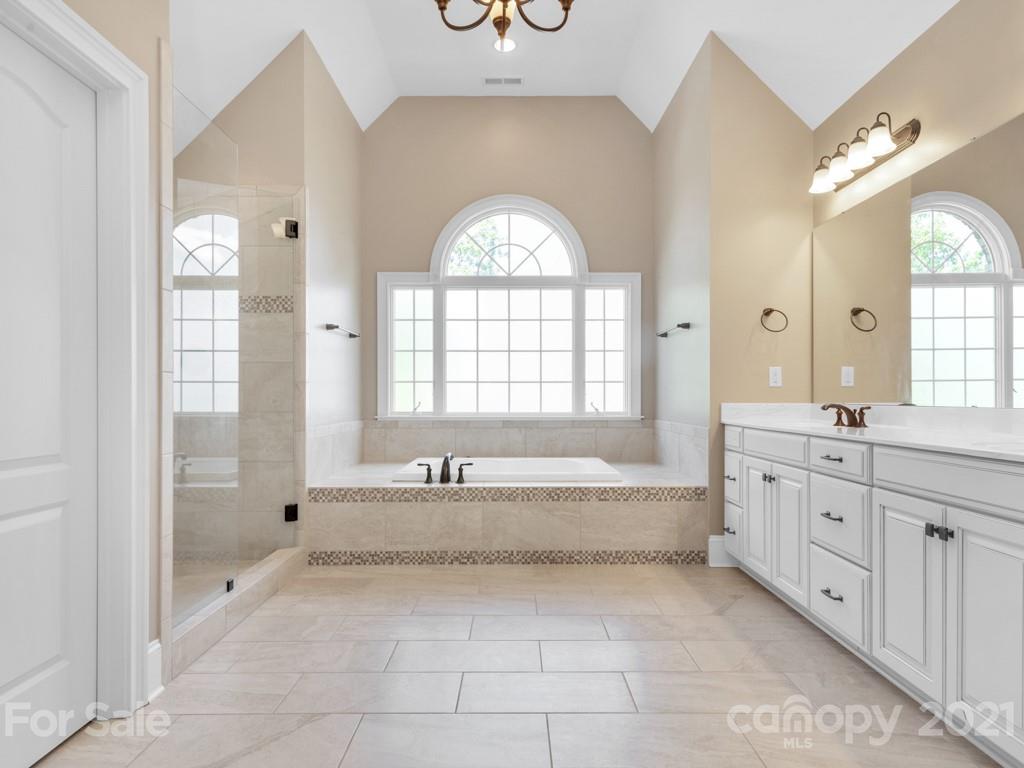 225 Cattle Ridge Road Marvin, NC 28173 - Photo 26 of 42 a spacious bathroom with a granite countertop tub shower a mirror and a sink