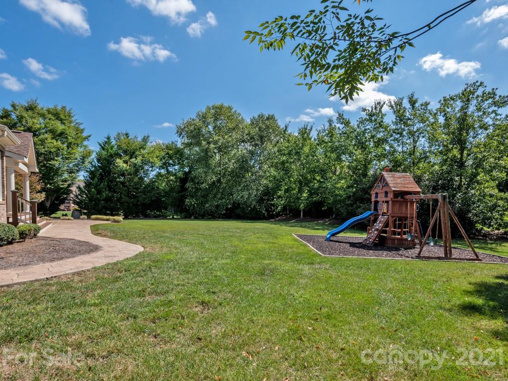 225 Cattle Ridge Road Marvin, NC 28173 - Photo 38 of 42 a view of a backyard with plants and a slide