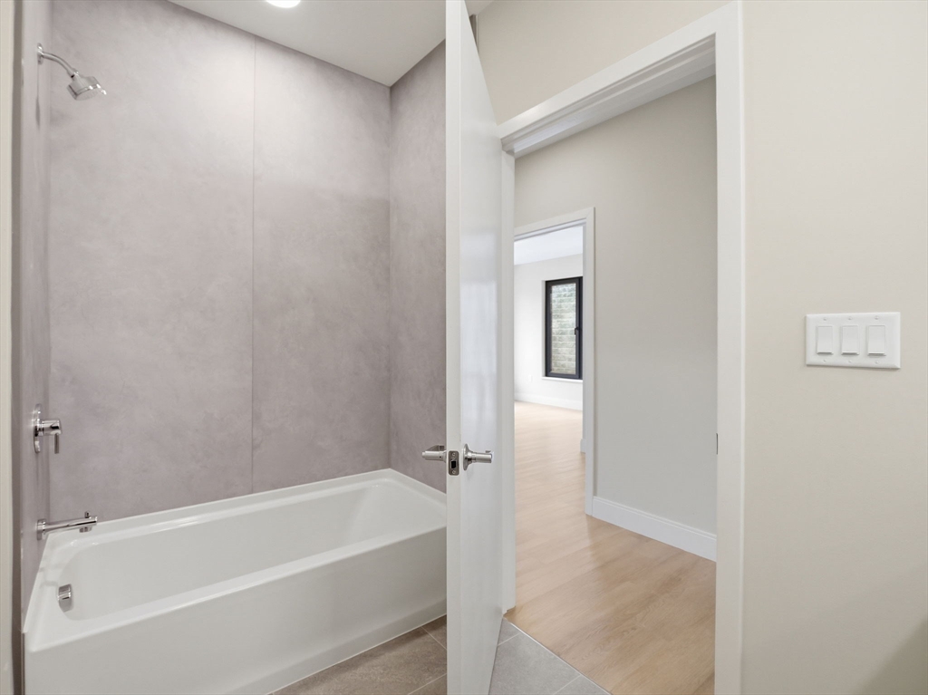 249 Corey Road, Unit 105 Boston, MA 02135 - Photo 13 of 41 a bathroom with a bathtub