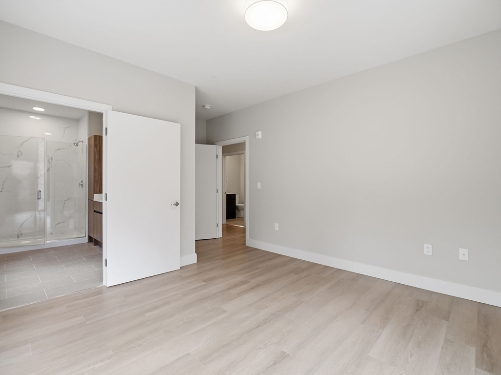 249 Corey Road, Unit 105 Boston, MA 02135 - Photo 20 of 41 a view of an empty room with wooden floor and closet