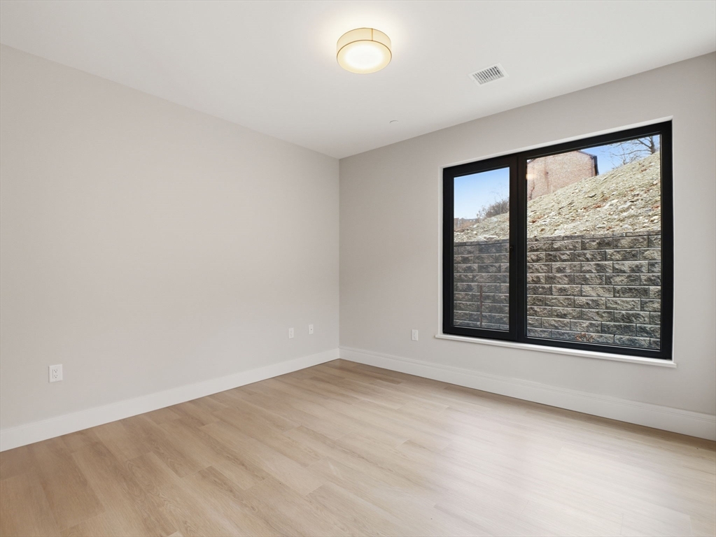 249 Corey Road, Unit 105 Boston, MA 02135 - Photo 21 of 41 an empty room with a window