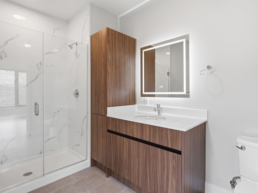 249 Corey Road, Unit 105 Boston, MA 02135 - Photo 22 of 41 a bathroom with a sink a shower and a mirror