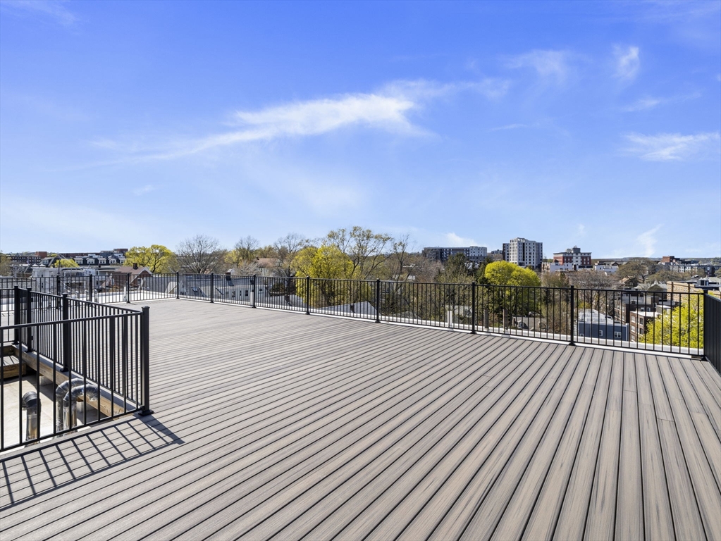 249 Corey Road, Unit 105 Boston, MA 02135 - Photo 30 of 41 a view of a balcony with wooden floor and city view