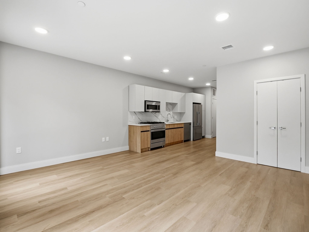 249 Corey Road, Unit 105 Boston, MA 02135 - Photo 5 of 41 a kitchen with stainless steel appliances a refrigerator and a stove top oven