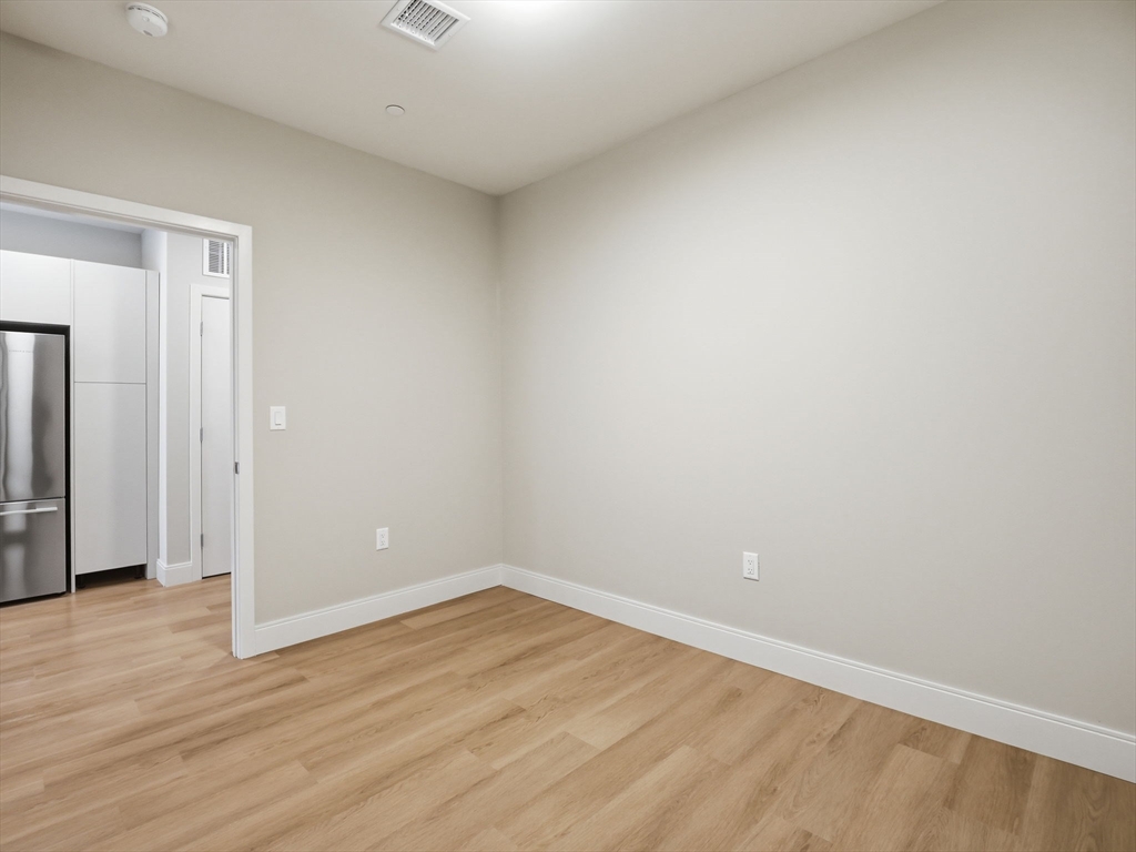 249 Corey Road, Unit 105 Boston, MA 02135 - Photo 8 of 41 a view of an empty room with wooden floor and closet
