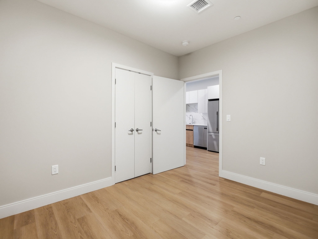 249 Corey Road, Unit 105 Boston, MA 02135 - Photo 9 of 41 a view of empty room with wooden floor