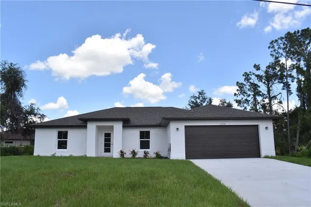 a front view of a house with a yard and garage