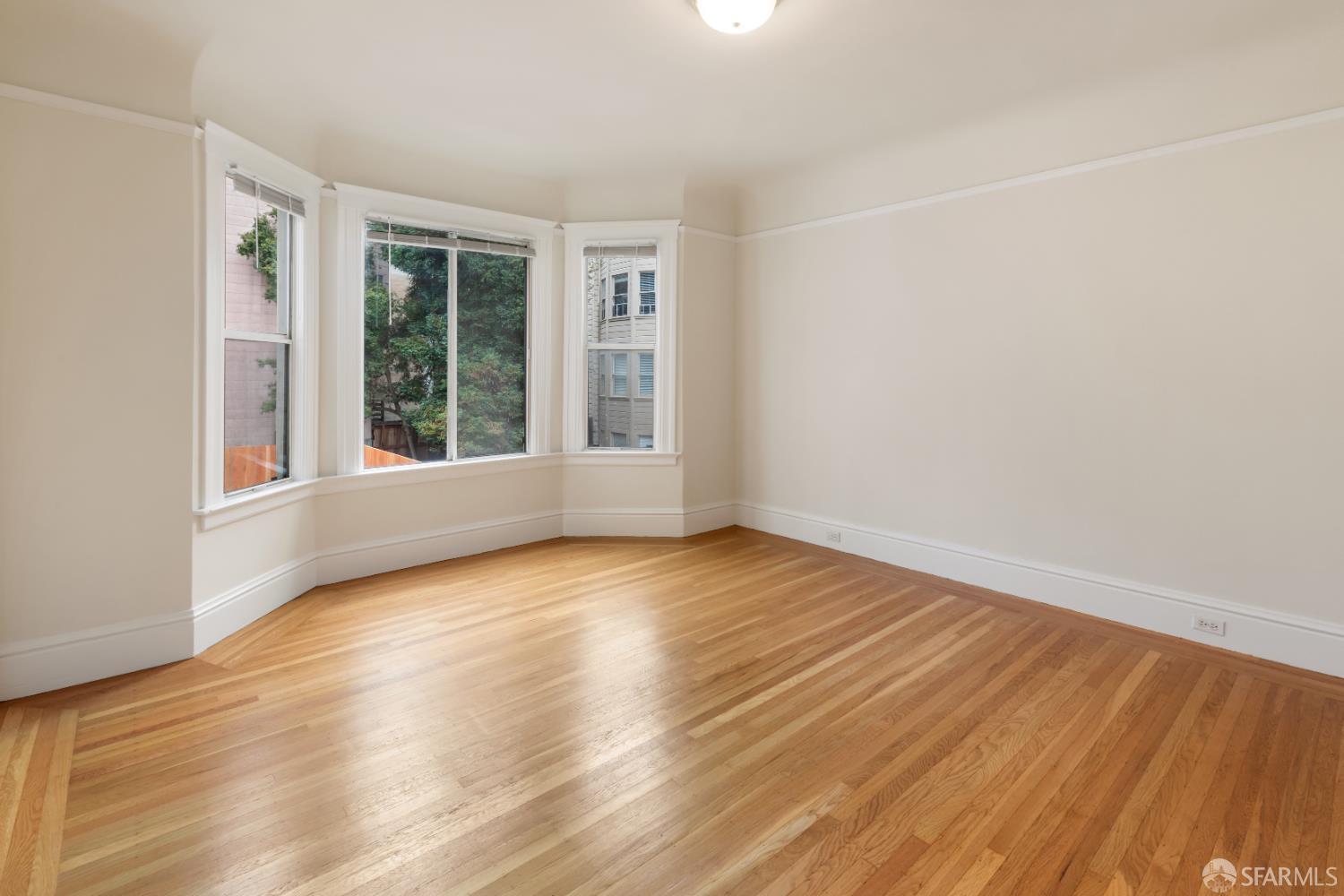 1338 Larkin Street San Francisco, CA 94109 - Photo 14 of 56 wooden floor in an empty room with a window
