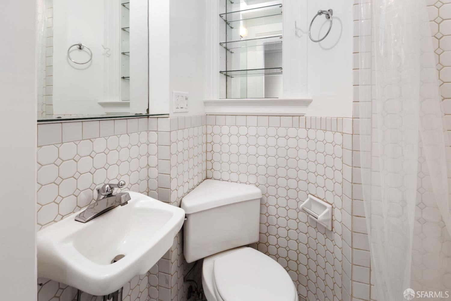 1338 Larkin Street San Francisco, CA 94109 - Photo 15 of 56 a bathroom with a toilet sink and mirror