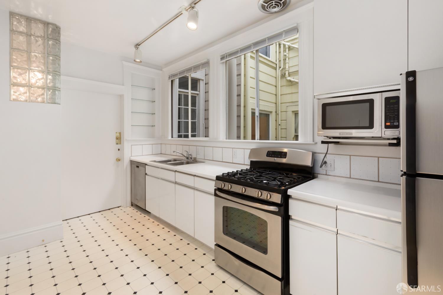 1338 Larkin Street San Francisco, CA 94109 - Photo 23 of 56 a kitchen with granite countertop a stove top oven sink and cabinets