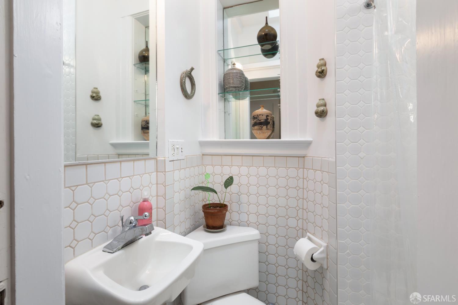 1338 Larkin Street San Francisco, CA 94109 - Photo 28 of 56 a bathroom with a sink and mirror with bathtub
