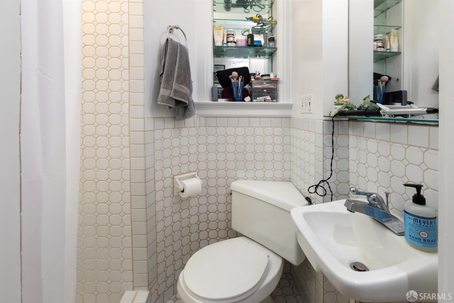 1338 Larkin Street San Francisco, CA 94109 - Photo 46 of 56 a bathroom with a toilet sink and mirror