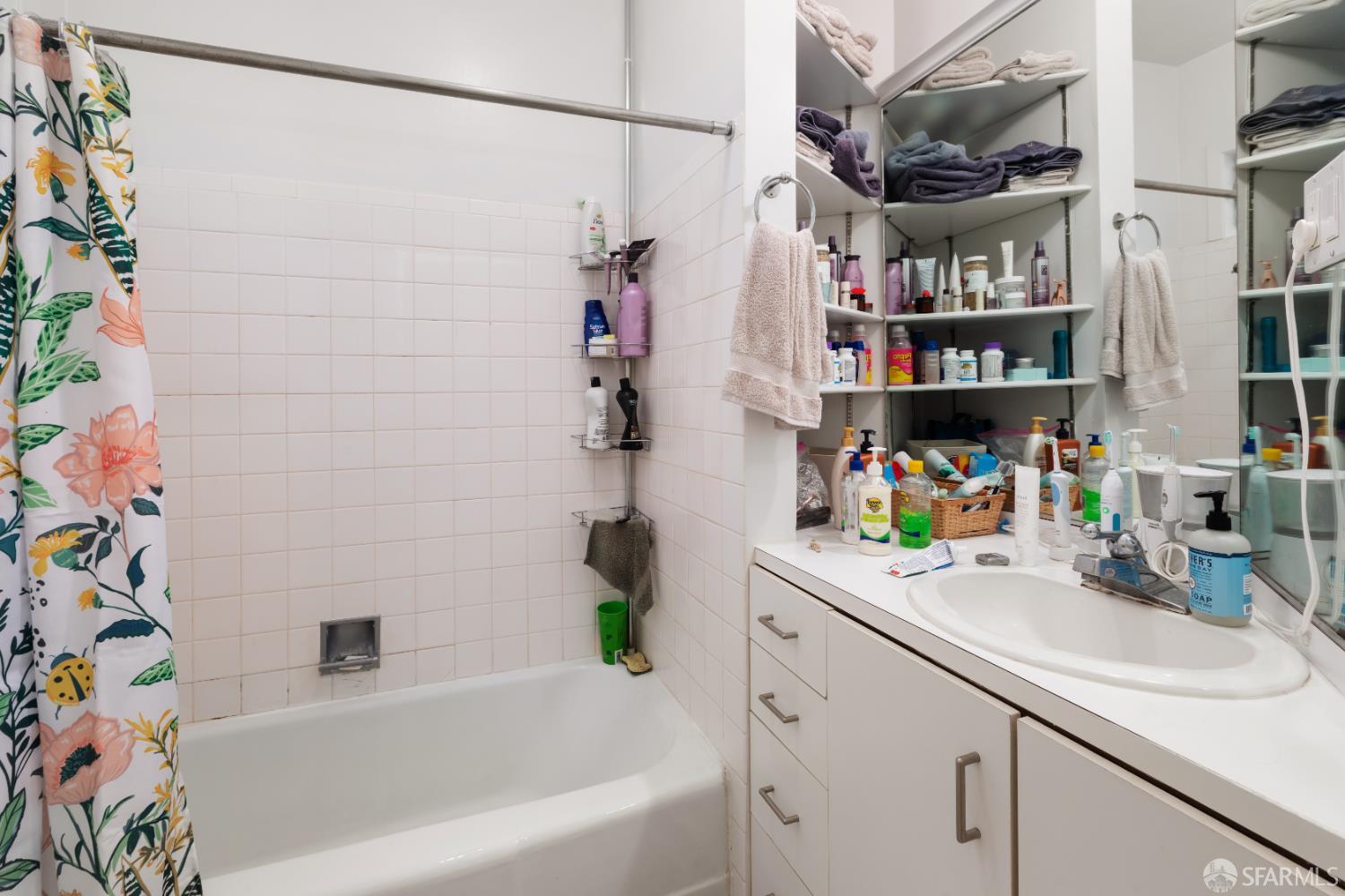 1338 Larkin Street San Francisco, CA 94109 - Photo 47 of 56 a bathroom with a bathtub a sink and a shower curtain