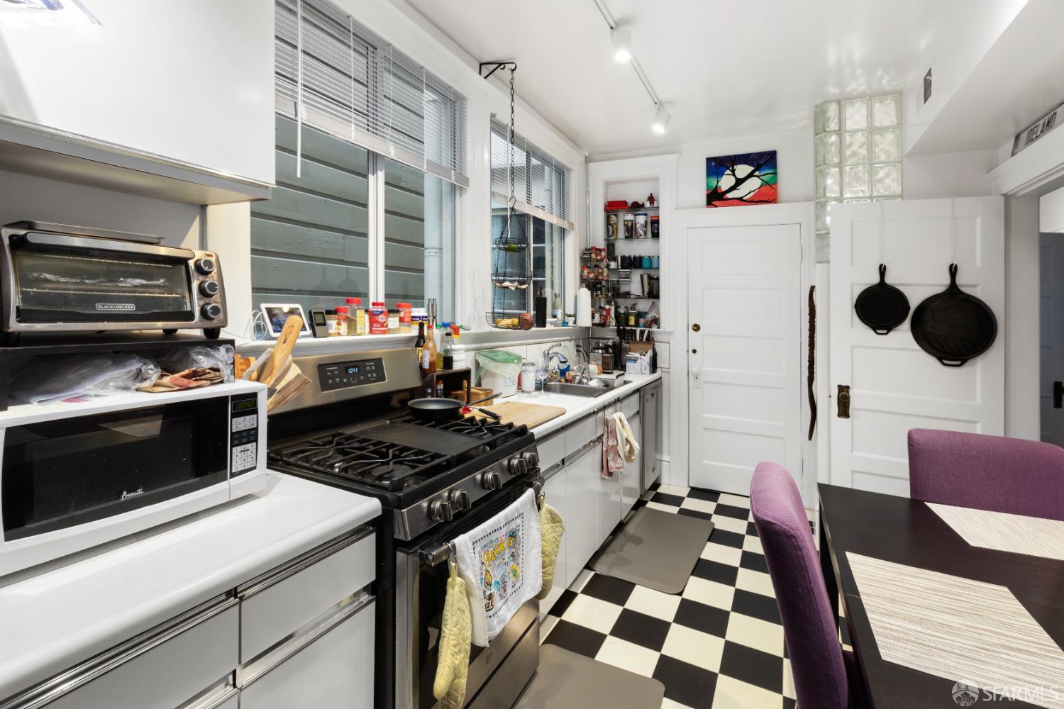 1338 Larkin Street San Francisco, CA 94109 - Photo 54 of 56 a kitchen with stainless steel appliances a stove a sink and a refrigerator