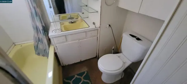 a white toilet sitting next to a sink and a mirror