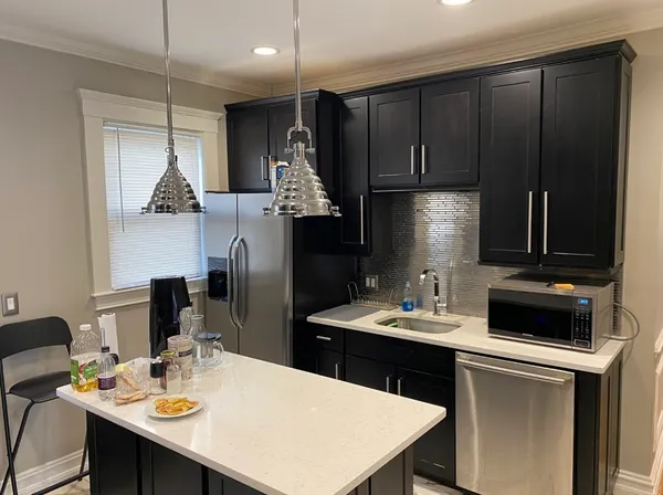 a kitchen with a refrigerator a stove a sink a dining table and chairs