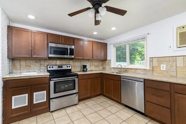 a kitchen with stainless steel appliances granite countertop stove top oven a sink dishwasher and a microwave oven on the blue kitchen countertops