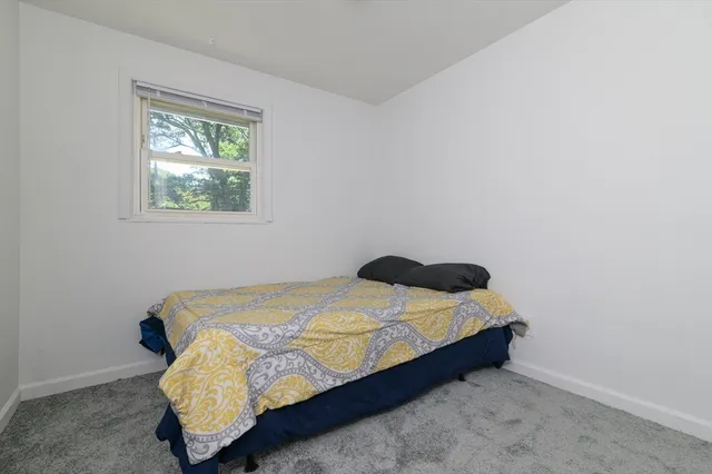a bed sitting in a bedroom next to a window