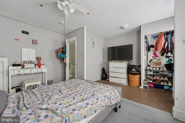 a bedroom with a bed and a flat tv screen on dresser