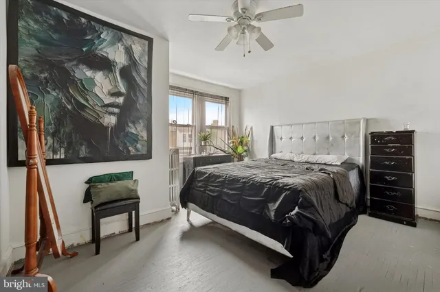 a bedroom with a bed and a painting on the wall