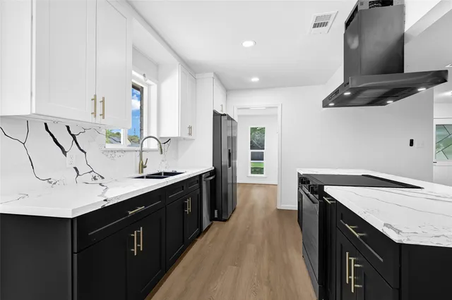 a kitchen with a sink dishwasher a stove and a refrigerator with wooden floor