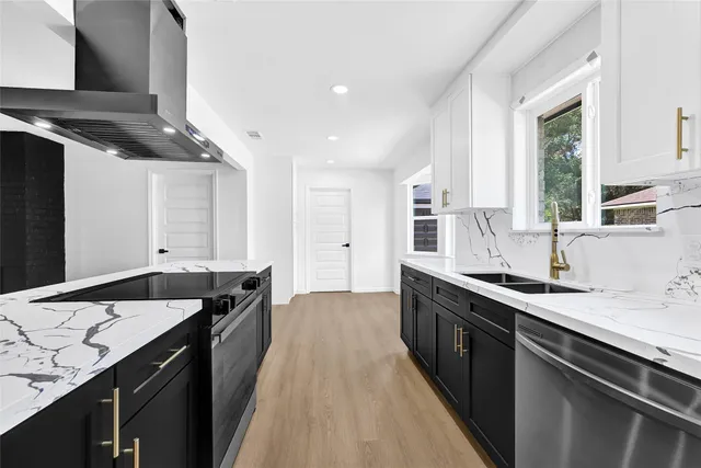 a kitchen with granite countertop stainless steel appliances a sink stove and cabinets