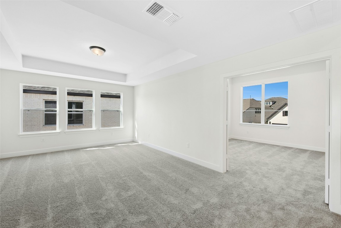 1533 Rodeo Ridge Drive Georgetown, TX 78628 - Photo 19 of 34 Empty room with light colored carpet and a raised ceiling