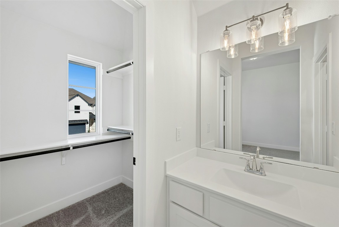1533 Rodeo Ridge Drive Georgetown, TX 78628 - Photo 22 of 34 Bathroom with vanity, dark carpet, and a spacious closet